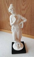 Front view of bisque figurine on black plinth