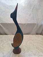 Left side view of entire bird figurine showing colors and pedestal base