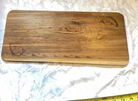 Front of cedar plank showing salmon engravings and grain