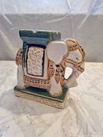 Front and side view of glazed ceramic elephant stand