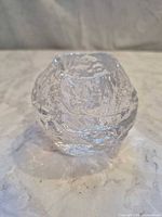 Angled front view of clear textured glass tealight holder