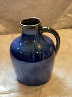 Front view of blue drip-glaze stoneware jug