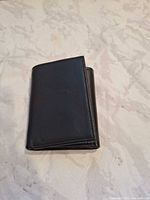 Wallet closed showing exterior black leather