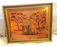 Front view of embossed copper giraffe artwork in frame