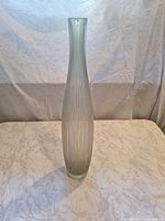 Full view of tall frosted gray ribbed vase standing upright