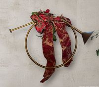 Front view of gold metal wall horn sconce with ribbon and poinsettias