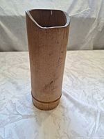 Front view of cylindrical bamboo vase showing overall shape and angled rim