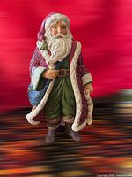 Front view of Jim Shore Santa figurine with detailed coat, satchel, staff