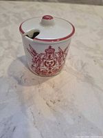 Front view of mustard pot with lid showing crest