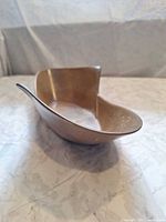 Front angled view showing asymmetrical shape and brown glaze of bowl