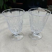 Both clear pressed glass wine goblets side by side