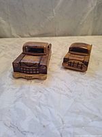 Front view of both carved wooden cars