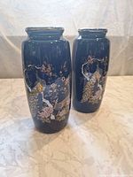 Front view of both cobalt blue vases showing peacock and floral design