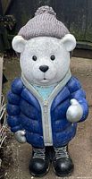 Front view of polar bear statue showing clothing details and pose