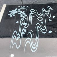 Close-up of black glass top showing floral and wave design