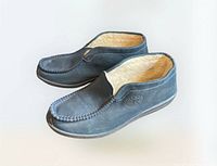 Side view of both slippers showing suede upper and shearling lining
