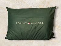 Front of pillow showing dark green side with TOMMY HILFIGER logo