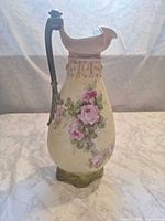 Front view showing floral decoration, handle and spout
