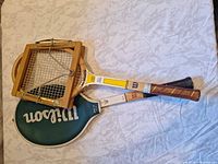 Both rackets side-by-side with cover and press visible