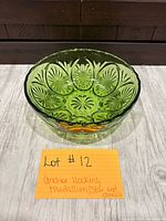 Top angled view of green pressed glass bowl showing overall form and decorative pattern