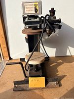 Full front view of Ashco dry pack canner showing frame, platform, lever and motor
