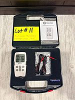 Open carry case showing all contents including device, wires, batteries, manual