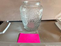 Front view of clear pressed glass vase showing floral pattern