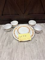 Full set showing 4 cups, stacked dinner and salad plates