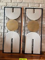 Both framed geometric wall hangings side by side with ruler for scale