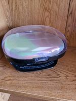 Top view of oval iridescent-lid UV/LED nail dryer on wood surface