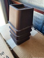 Stacked view of the four brown plastic bed risers