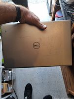 Closed Dell laptop top showing Dell logo and surface scratches