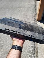 Top view of black JBL amplifier showing overall size, dust and wear