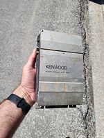 Front/top view of Kenwood KAC-524 amplifier showing logo, finish and wear