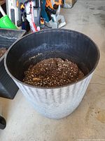 Overall view of gray plastic/resin planter containing potting soil