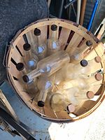 Top-down view of glass bottles inside wooden bushel basket