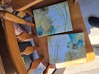 Two abstract square canvas prints on chair, showing coloration and design