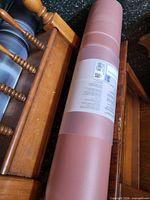Rolled pink yoga mat with factory label visible