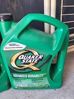 Front view of green Quaker State Advanced Durability motor oil jug, showing label details