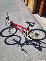 Full side view of red and yellow 26" mountain bike standing on kickstand