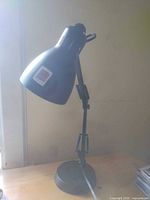 Side view of black adjustable desk lamp on table