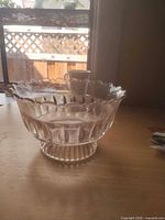 Side view of clear pressed glass compote showing ruffled rim and pedestal foot
