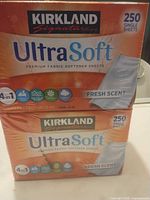 Front view of two shrink-wrapped boxes showing brand, product name, sheet count and scent