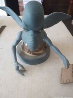 Front view of blue Watto bust holding plaque