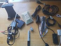 Overhead of entire lot showing cables, chargers, stand, wall tap, plug adapter, LED light