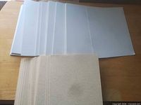 Stack of white backing boards and beige parchment sheets