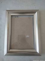 Front view of brushed aluminum 8x10 frame with glass and placeholder board