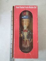 Front of red window box showing Uncle Sam wobble figurine inside
