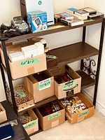 Overall view of shelving unit with contents showing four tiers and metal frame