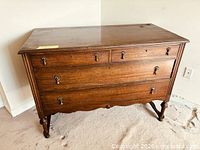 Front view of mahogany chest showing four drawers and brass pulls